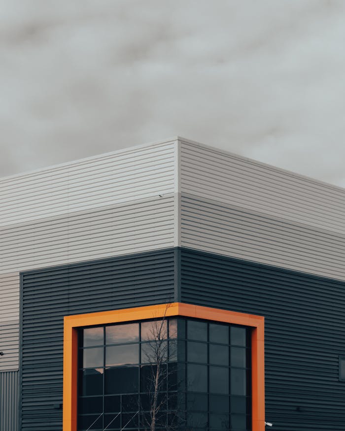 A modern industrial building against a cloudy sky, featuring sleek exterior design.