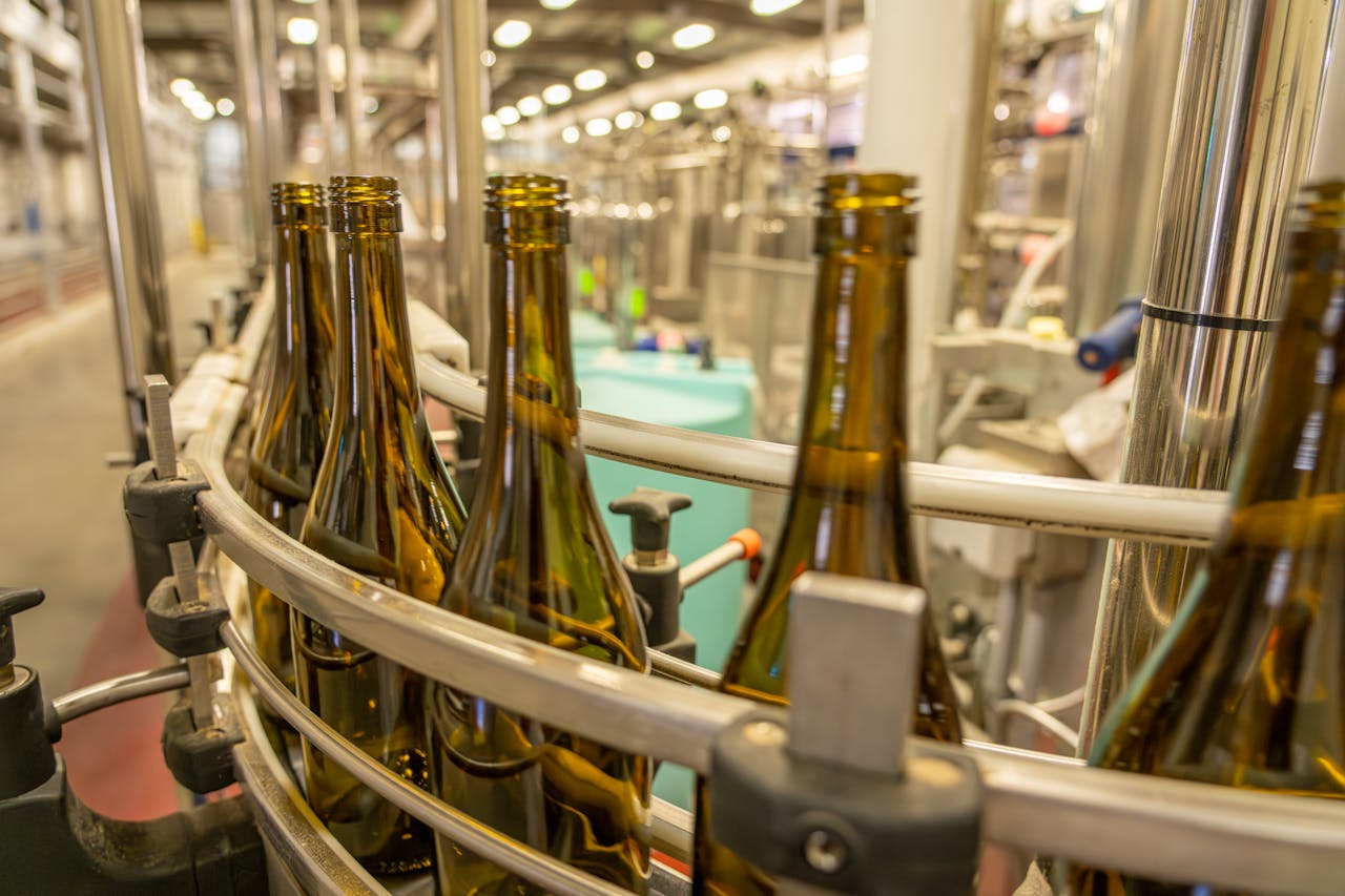 our-story Close-up view of glass bottles on an industrial production line in a manufacturing facility.